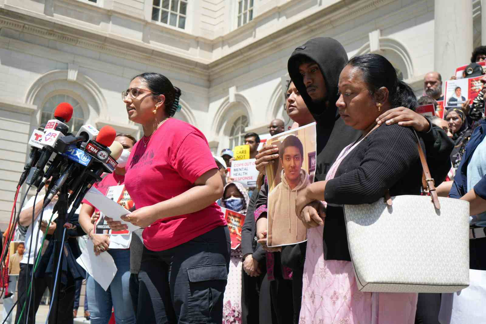 Win Rozario's mother and brother with community members at City Hall steps (Ayesha Le Breton for The Juggernaut)