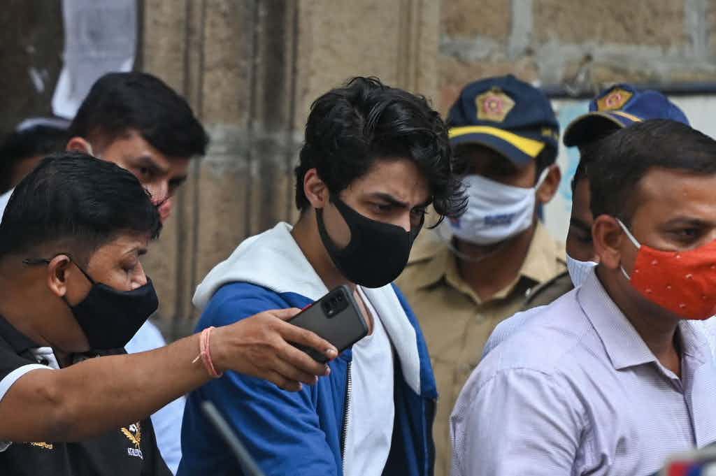 Aryan Khan (center) is escorted to court by Narcotics Control Bureau (NCB) officials for a bail plea hearing in Mumbai on October 8, 2021, after his arrest in connection with a drug case. (Photo by Punit Paranjpe/AFP via Getty Images)