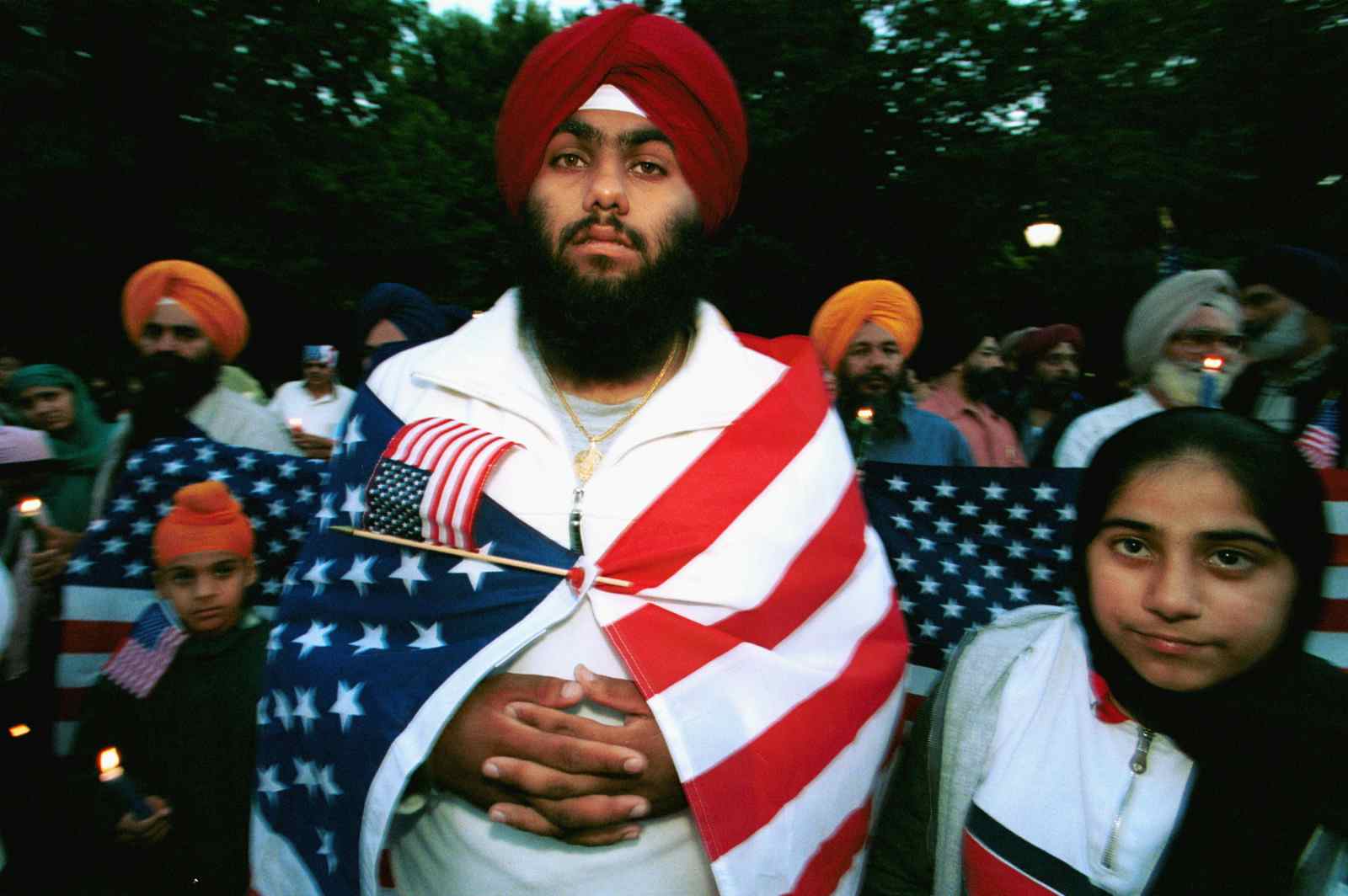 A Sikh wrapped in an American flag attends a candlelight vigil for victims of the World Trade Center attacks September 15, 2001 in Central Park in New York City (Robert Nickelsberg/Getty Images)
