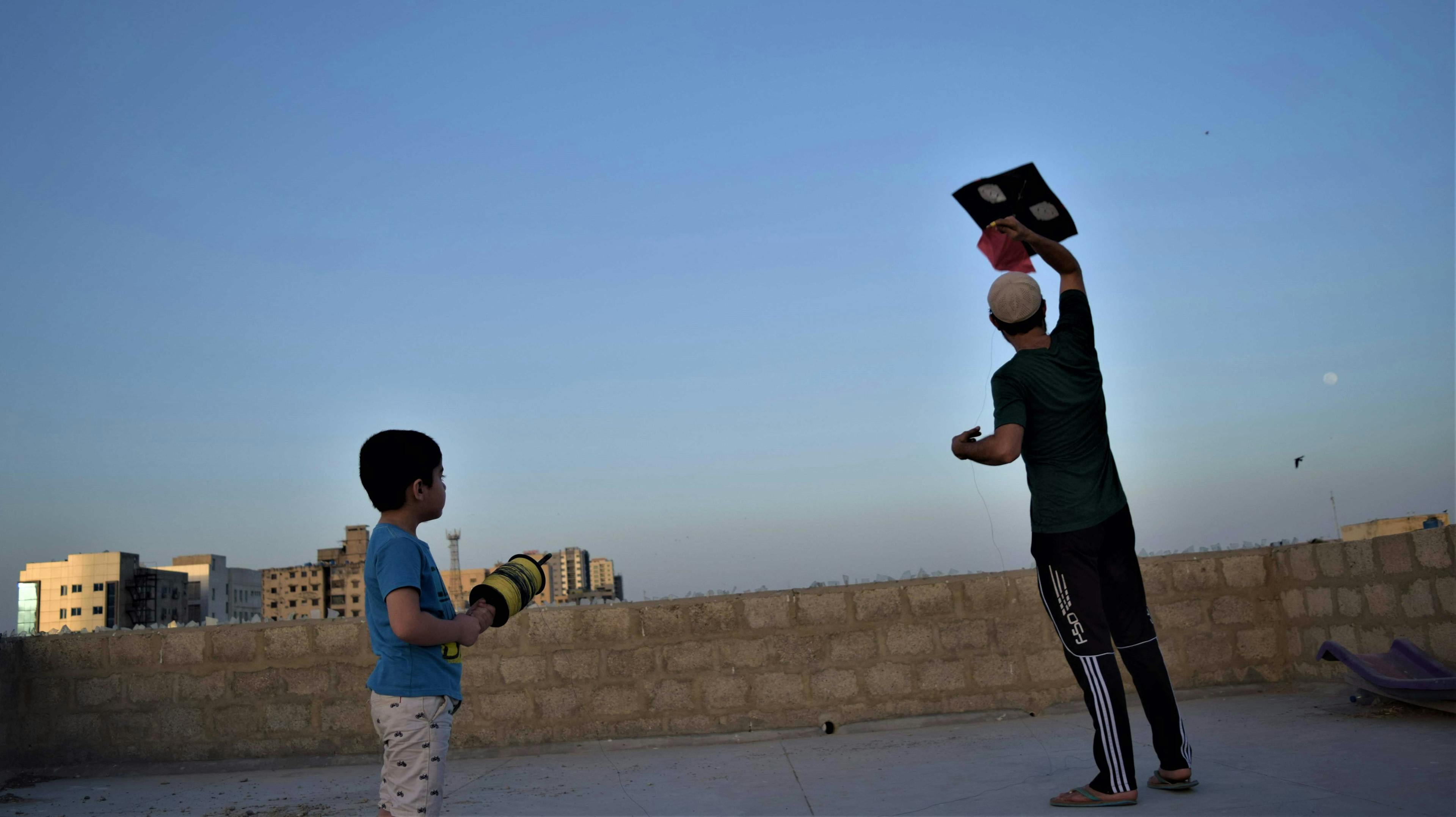 Mahad Saqib watches his father get a kite airborne. (Aysha Imtiaz)