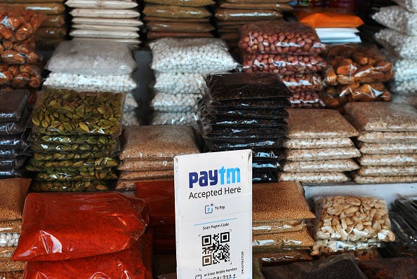 A sign for the PayTM online payment method, operated by One97 Communications Ltd., is displayed next to bags of spices at a wholesale market in Delhi, India, on Friday, Nov. 25, 2016. (Anindito Mukherjee/Bloomberg via Getty Images)