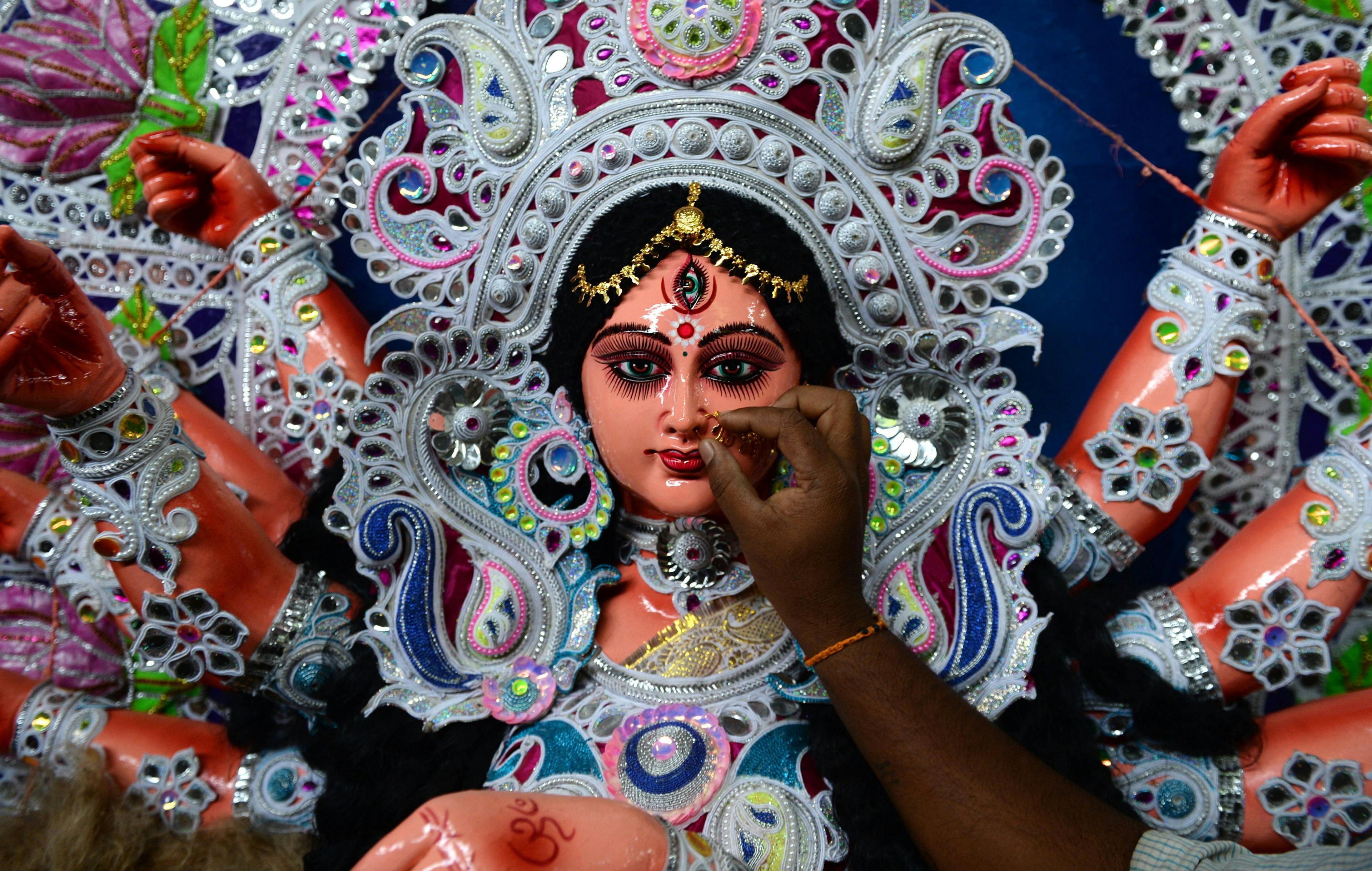 An Indian artisan puts a nose ring as he gives finishing touches on a clay idol of the Hindu Goddess Durga at his workshop in Chennai. (Photo credit should read ARUN SANKAR/AFP via Getty Images)