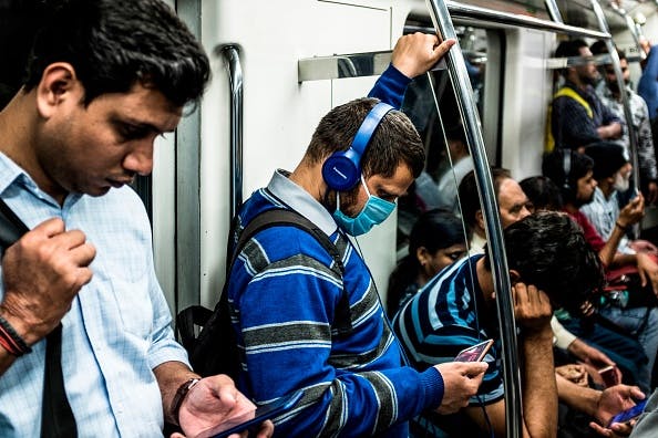 A commuter wearing a facemask while traveling on the Delhi Metro, on March 12, 2020. (Photo by XAVIER GALIANA/AFP via Getty Images)