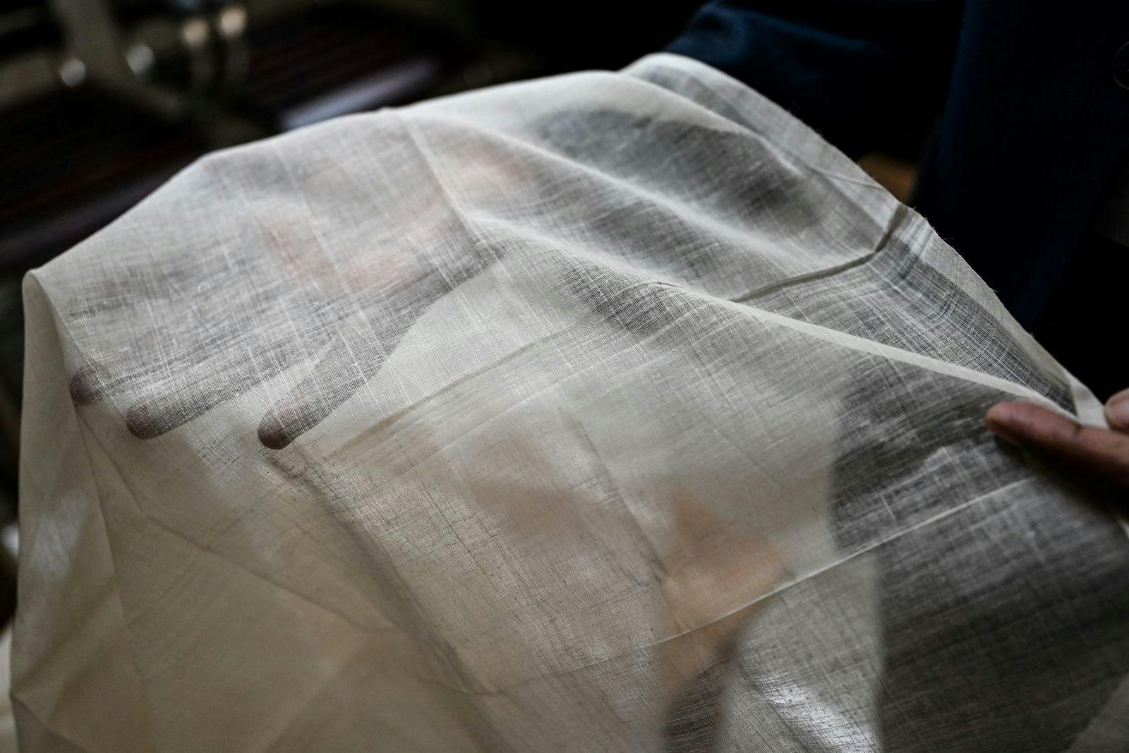 Ayub Ali, a senior government official helping shepherd the Dhaka muslin revival project, displaying a piece of muslin cloth in his office in Dhaka, January 2022 (Munir uz zaman / AFP via Getty Images)